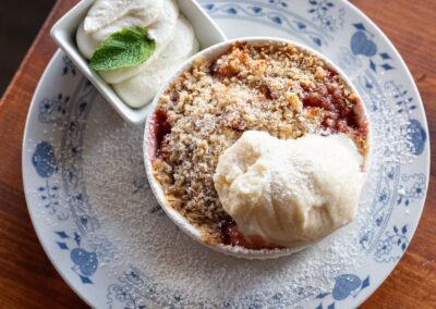 Horký Crumble se sezónním ovocem, s mandlovou drobenkou a chlazenou zakysanou smetanou, kopeček vanilkové zmrzliny